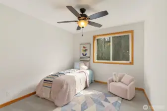 Spacious upstairs room at the end of the hallway, featuring a ceiling fan and a walk-in closet.