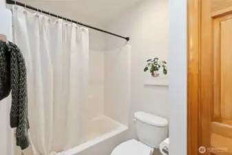 Upstairs full bathroom featuring a tub/shower combination and generous linen closet storage.
