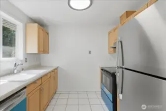 Kitchen with all new stainless steel appliances (there is a protective blue cover on the dishwasher and range/oven)