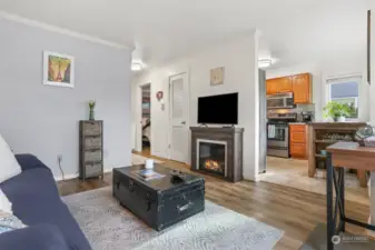 Living room looking at fire place and kitchen.