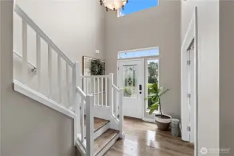 The impressive two-story entry features a front door with sidelights and a transom window, creating a bright and open feel.