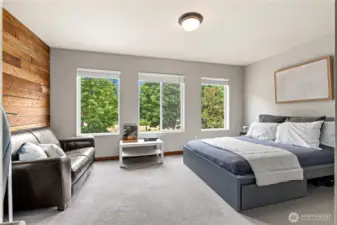 Find a calming retreat in this well-appointed room. The combination of natural light, a peaceful view, and a warm wood accent wall makes this an ideal space for relaxation, study, or hosting overnight guests.