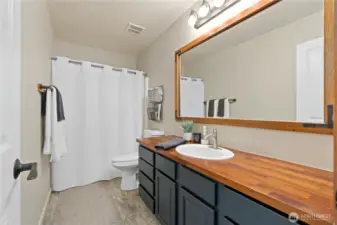 A full bath featuring a wood countertop, a modern sink, and a shower/tub combination.