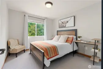 This bedroom features a large window, making it ideal for a home office or guest room.