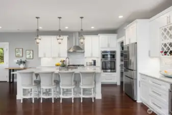 Stunning gourmet kitchen with stone counters, tile backsplash, and all stainless appliances