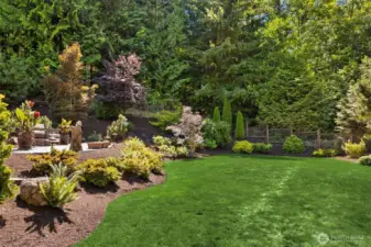 Fenced, and beautifully cared for landscaping with gardens and lawns.