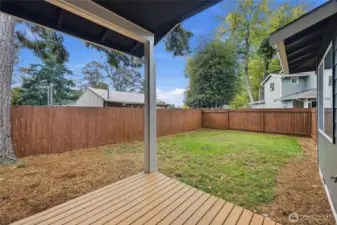 Fully fenced large backyard with cozy covered back deck.