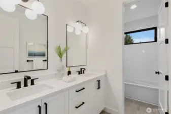 Upper level bathroom with double sinks and bathtub on the upper floor