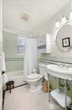 Hexagon floor tiles and large pedestal sink add to the charm of this home