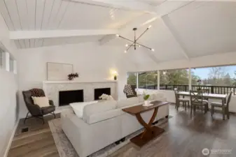 Main Level Living Room with all new Luxury Vinyl Plank Flooring with real wood baseboards. Fireplace refresh using Carrara marble herringbone mosaic tile, new mantle and surround. Firebox and wood storage have custonm aluminum trim.