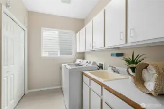 Laundry room with built-ins for additional storage and a sink for added convenience.