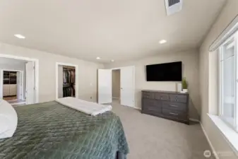 Another view of the primary suite with one of two closets in the distance