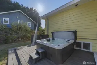 Back deck with hot tub, overlooking the landscaped 8,160 sq ft lot.