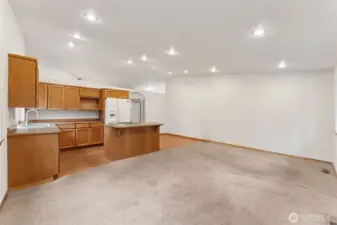 This view shows the heart of the home in action. The family room and kitchen share the vaulted space, giving the area an easy flow and plenty of light. Off to the side, the hardwood zone creates a natural place for a breakfast table, work nook, or hobby corner without crowding the main seating area. It’s a flexible pocket of space that lets the home adjust to your routine instead of the other way around.