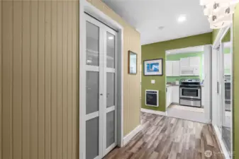 Foyer inside unit - glass paneled door to the left is a storage closet - kitchen is ahead - bedroom to the right - living area to the left