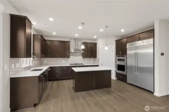 Well-appointed kitchen with gas cooktop, 48" counter depth side-by-side refrigerator. Plenty of space to entertain!  Home for sale will include white cabinetry.