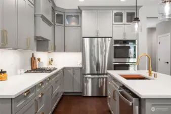 The large gourmet kitchen features stainless appliances and quartz countertops.