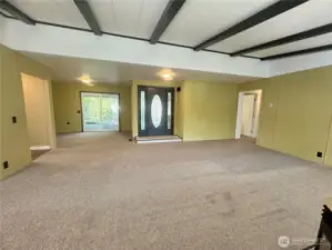 This is the living room, with its beautiful front door and door-side windows. To the left is the dining room's patio door, leading out to the deck and waterfront.
