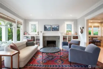 The living room with a custom fireplace surround and shelves for books, mementos and photos.