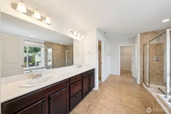 Primary bath with two walk in closets in the distance