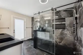 Primary En Suite Bath: Feels like a Luxury Hotel!! Fully Tiled Wall.. 6’ Tiled Shower w/Glass Walls & Sliding Door, Granite Accents, Shower Tower Multifunction Shower Panel System in Stainless w/Handheld Wand & Rainfall Shower Head. Access to Backyard/Pool/Hot Tub via Frosted Glass Door.