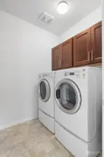 Laundry room with utility sink and storage conveniently located upstairs.