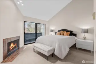 Primary ensuite bedroom with fireplace and deck