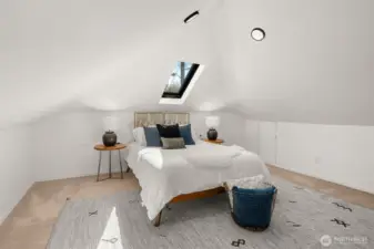 Spacious vaulted primary bedroom, features mini splits, skylight, and a custom closet fixtures.