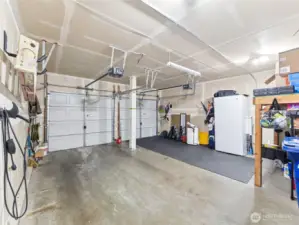 Spacious 2-car garage w/openers & some shelving for added storage. Plus 240 volt plug-in for EV.