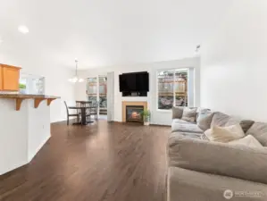 Great Room featuring wood laminate floor, high ceilings, & gas fireplace.