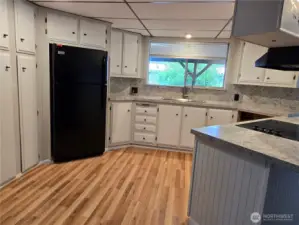 Newer kitchen flooring and freshly painted cupboards