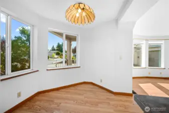 Charming breakfast nook with hardwood floors, bright windows, and warm natural light.