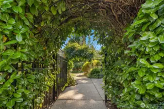 This beautiful, gated laurel archway leads to the front entry and patio sitting area.