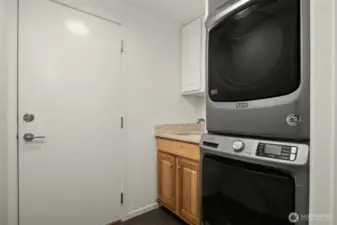 Laundry / mud room with ample cabinet space and sink. Door leads to two car garage.