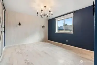 Primary bedroom, new ceiling lighting, new flooring on the left is a large walk in closet with barn door