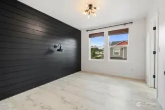 Bedroom 3 has two venting windows with wooden blinds, black shiplap wall and walk in closet. The lwall light iis for decor purposes only, otherwise non functional.