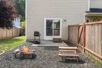 Close up of patio off sliders, fire pit and graveled area next to lawn
