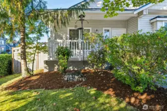 Sweet front porch with mature landscaping all around.