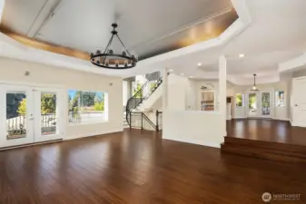 Spacious west-facing living room is practically ballroom-sized! French doors lead to balcony. Clips on ceiling were installed by seller for aerials exercise practice; could also be used for hanging chairs or plants.