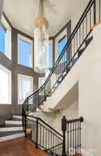 Ornate metal railings and granite steps adorn the curving stairwell joining the main and upper floors.