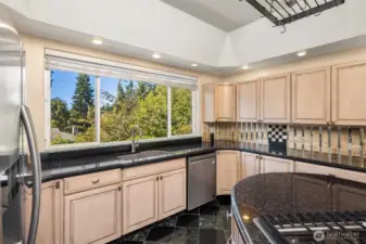 Well-laid-out kitchen with granite counters, abundant cabinets, double oven, and long lengths of counter for meal prep.