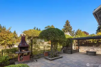 Charming stone patio with metal gate, pergola, and gas fire pit (convey with sale).