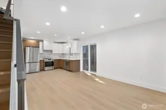 entry view to living area kitchen and sliding door to the side yard