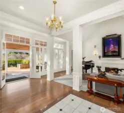 The entry features three sets of French doors opening to seamless, opulent entertaining.