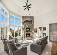 The grand family room showcases a curated, floor-to-ceiling statement fireplace.