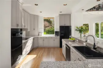 The spacious kitchen features quartz countertops, custom cabinetry, a walk-in pantry, and a prep station with bar sink.