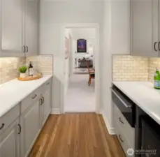 The butler’s pantry is smartly positioned between kitchen and formal dining, featuring quartz counters, a warming drawer, and wine cooler.