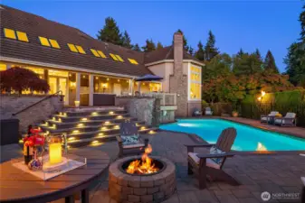 By night, the pool and landscape glow with a resort-like ambiance—perfect for fireside lounging and roasting marshmallows.