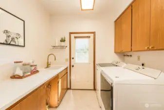 Utility Room with Refrigerator and storage has door to outside gated yard