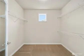 Large walk-in closet with a window for natural light.